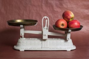Imagen de balanza con manzanas, una fuente de vitamina